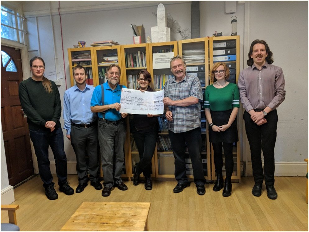 Cast and crew of Peculiar Production's performance of Terry Pratchett's The Truth meet with Cardiff Mind CEO to donate £5,000 following the show's success.